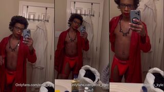 Femboy poses de roupão vermelho e calcinha fio dental para uma selfie no espelho do banheiro